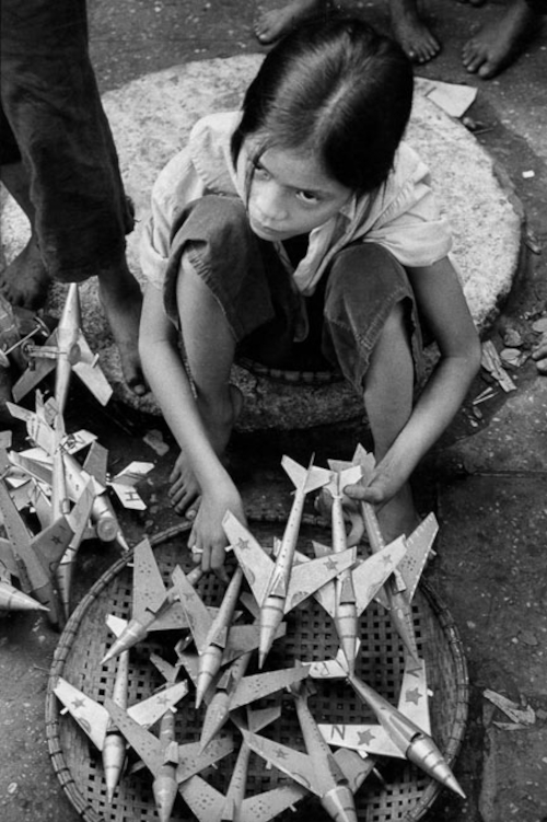 Fillette vendant des avions miniatures, répliques de MIG utilisés par l'armée du Nord, Hanoi, 1969 © Marc Riboud / Fonds Marc Riboud au MNAAG